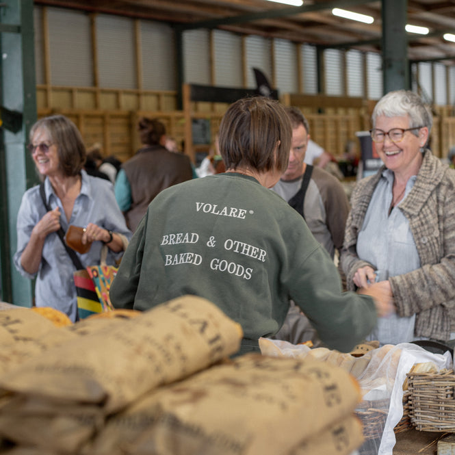 Kay serving customer from Volare Bread stand at Farmers Market