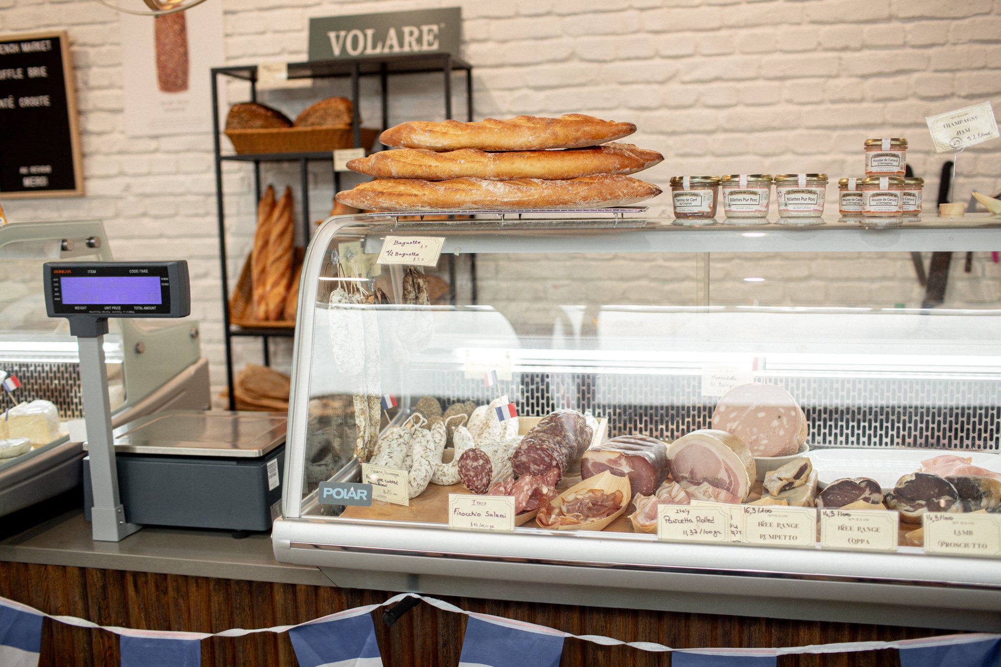 Volare baguettes sitting atop a cabinet of cured meats at Taupo French Market