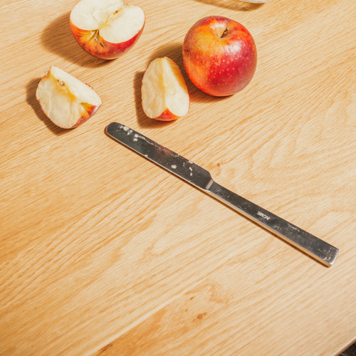 Acme knife with apple slices on a wooden surface