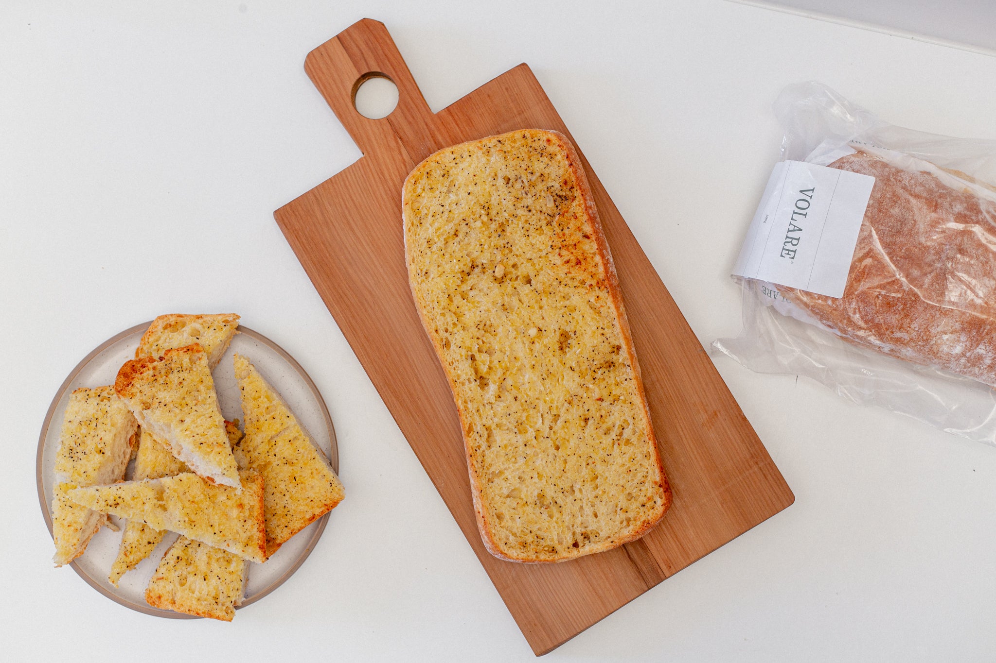 Volare Frozen Garlic Bread baked at home and laid out on a wooden chopping board