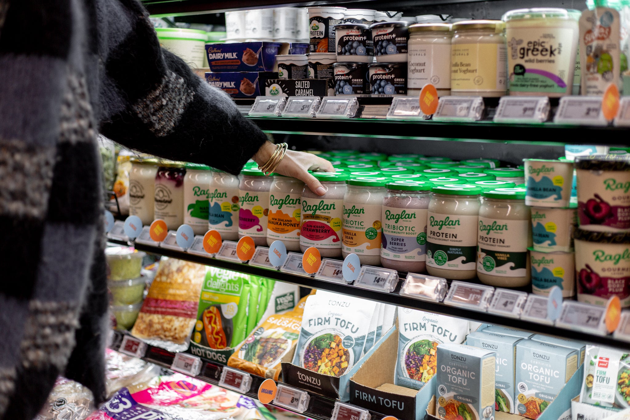Reaching for a jar of Raglan Food Co. Coconut Yoghurt in the chilled aisle at Raglan Four Square