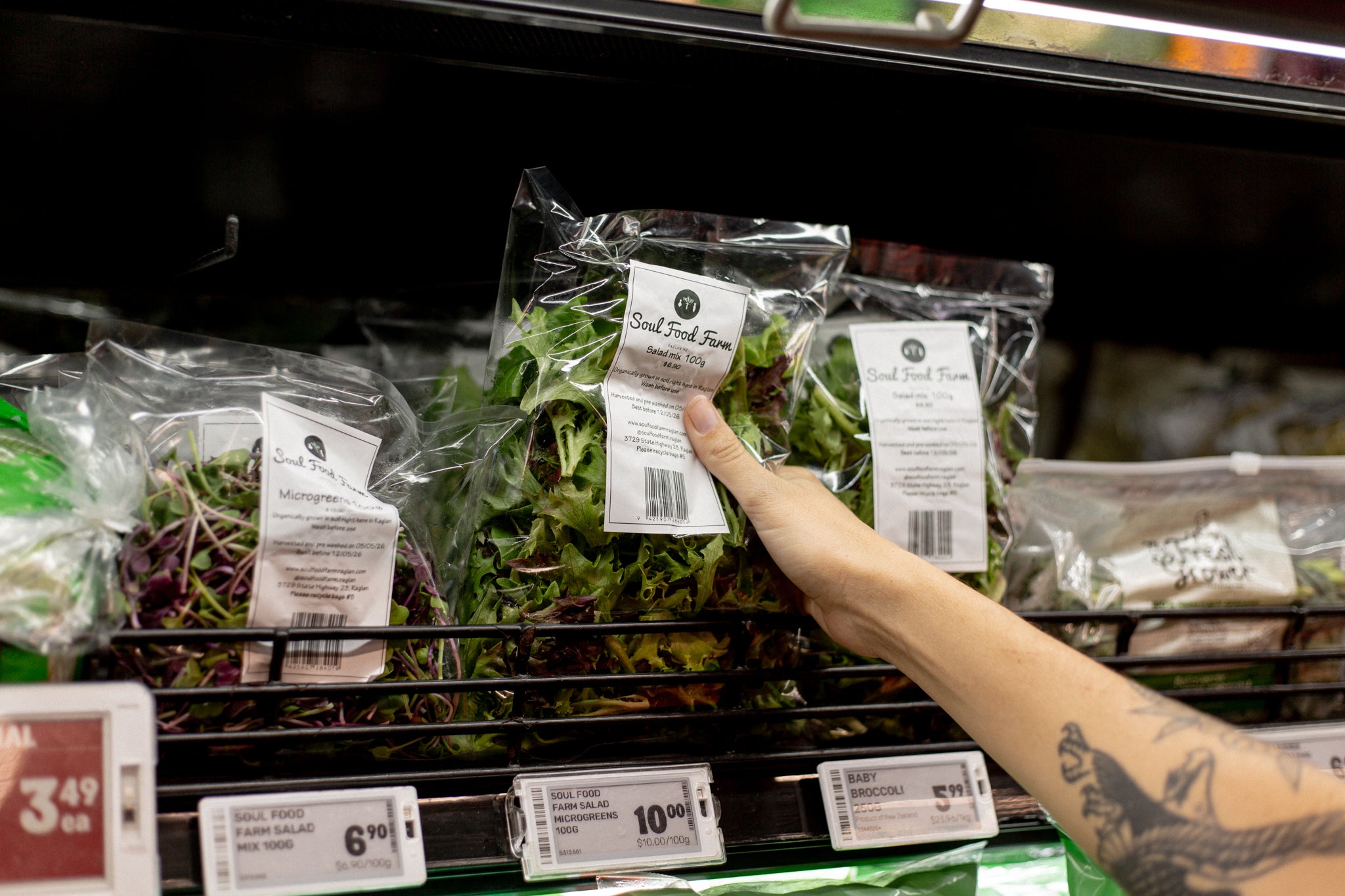 Arm grabbing a bag of Soul Food Farm lettuce at Raglan Four Square