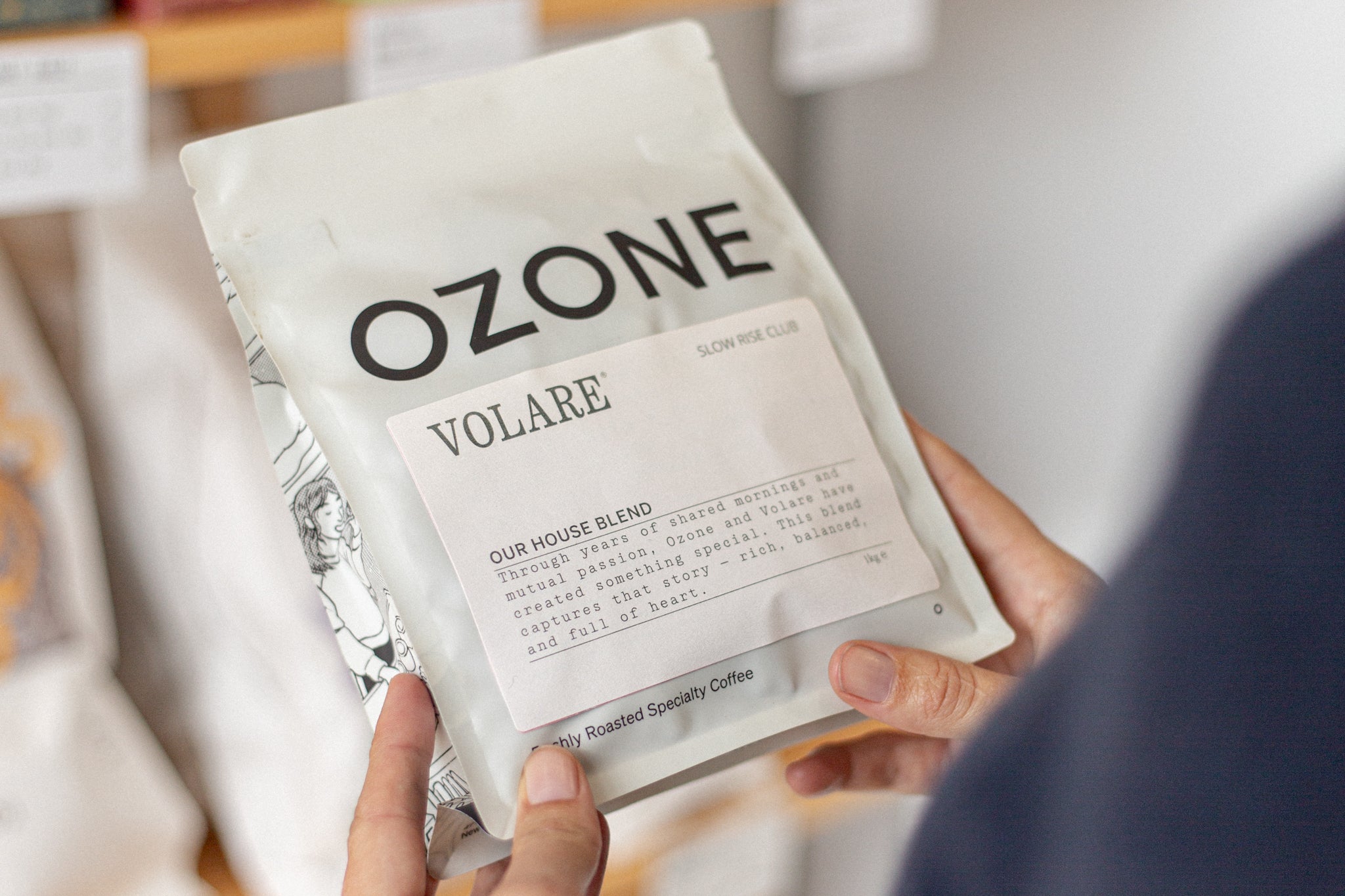 Hands holding Ozone coffee with Volare Slow Rise Club label on the front