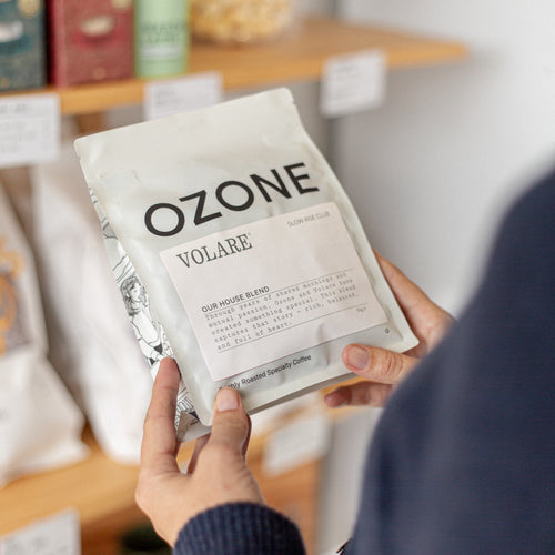 Person holding a coffee package labeled 