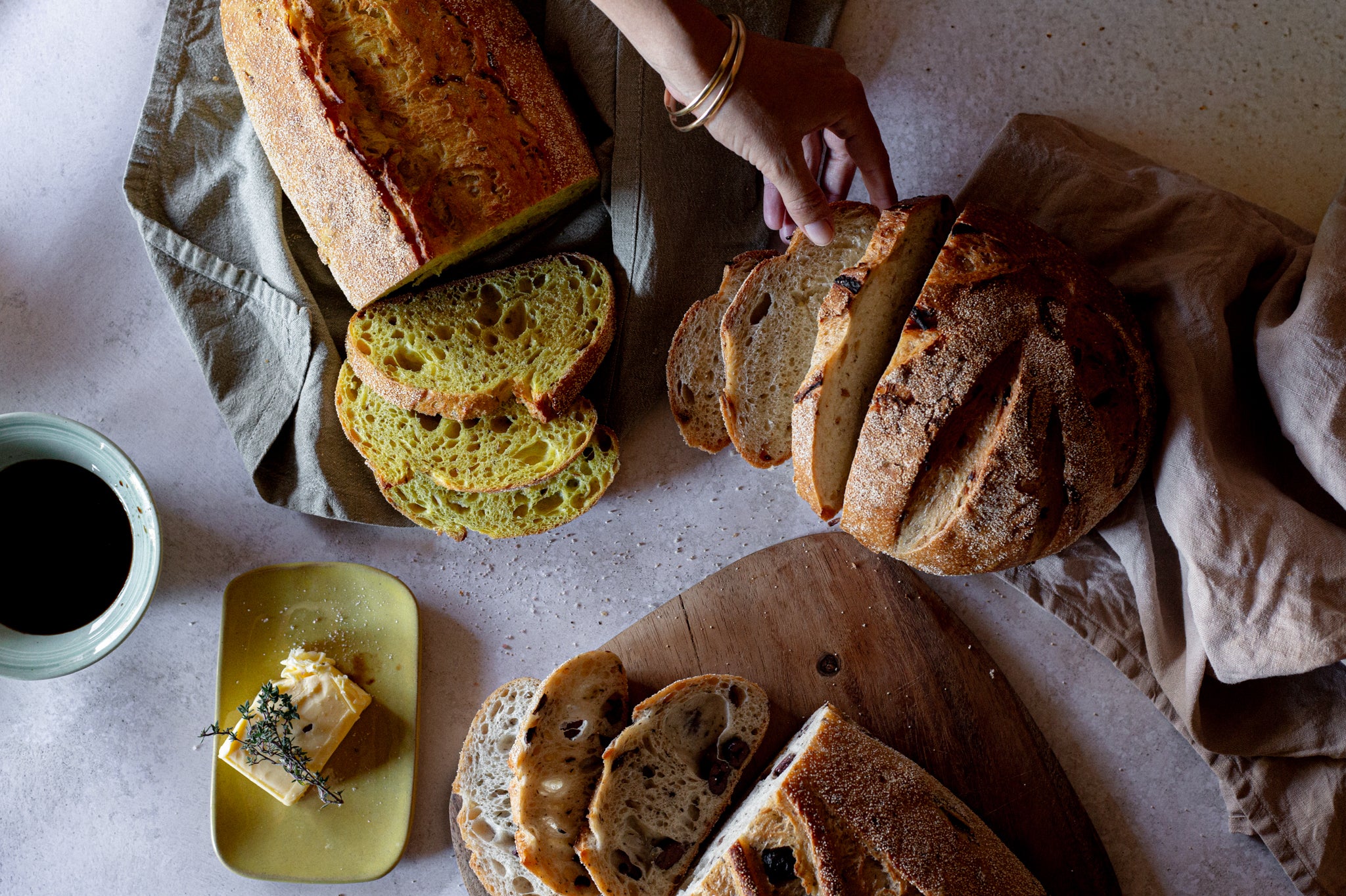 Volare Loaves of bread sliced on a table next to a dish of butter