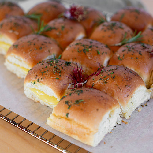Melted cheese oozing out the side of a group of Volare sliders arranged in a Christmas tree