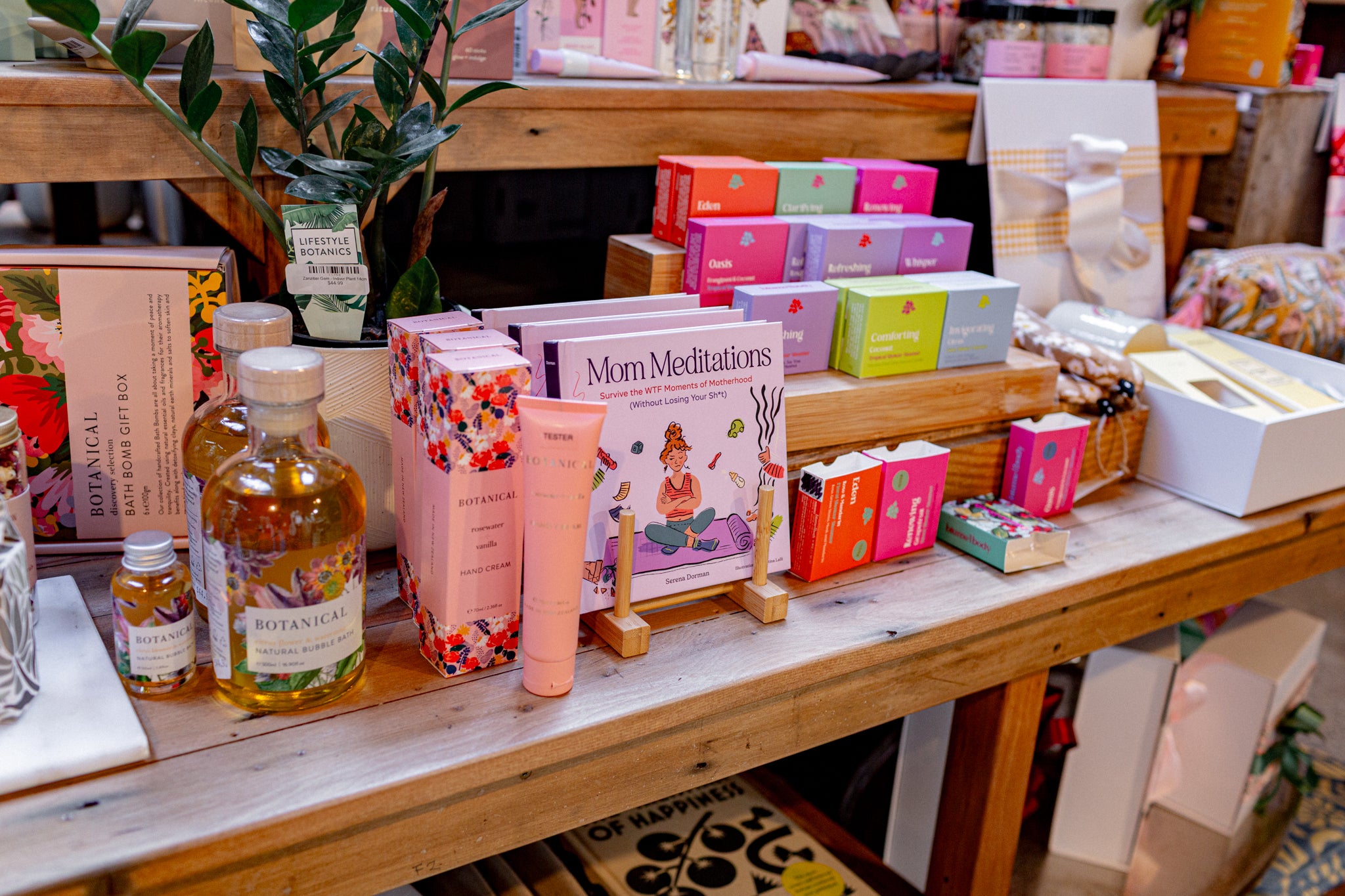 Shelves displaying essentials for motherhood and care items (bath bombs, hand creams and meditation book)