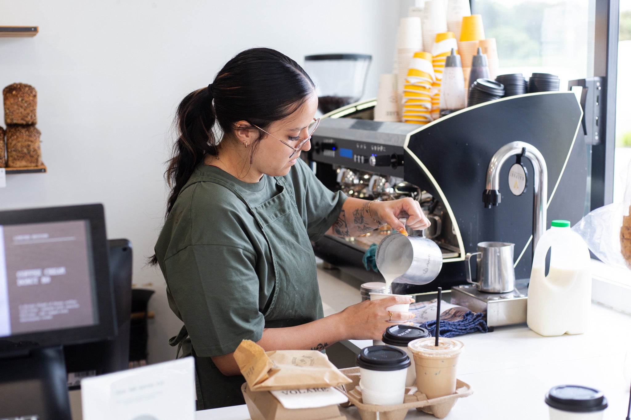 Kelly pouring coffee at the Volare main bakery store