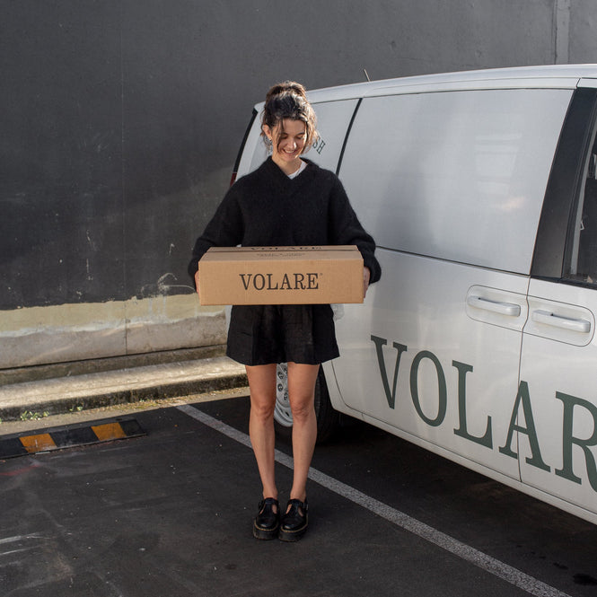 Person holding a box labeled 