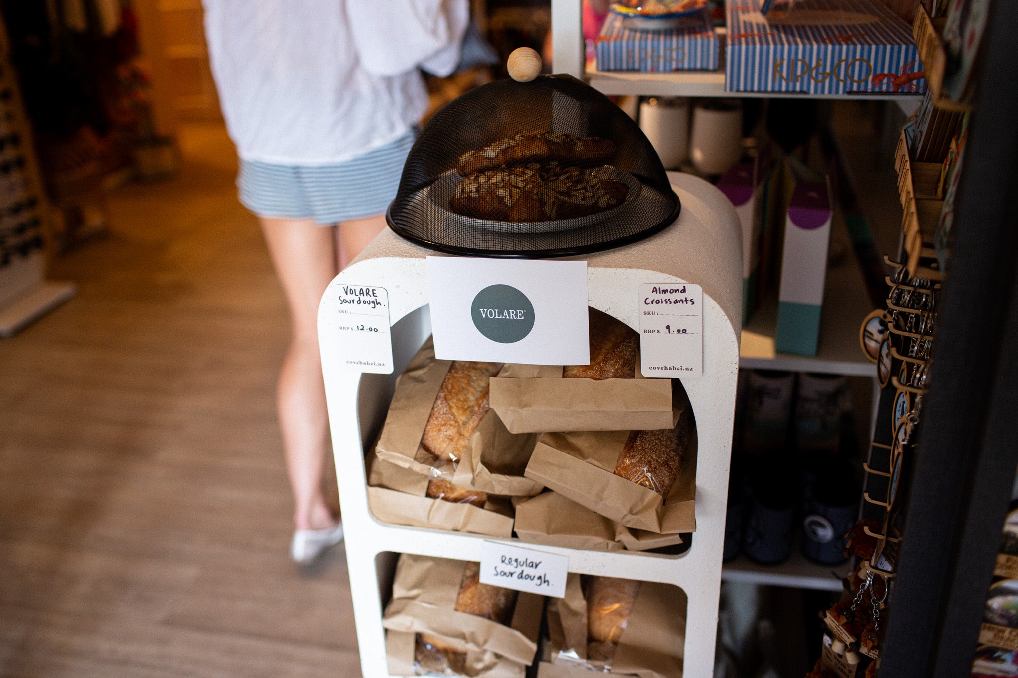 Display of Volare bread at Cove Beach Essentials in Hahei with a person in the background