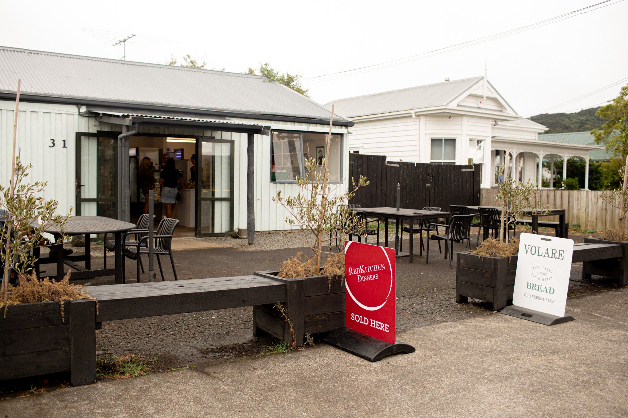 Volare and Red Kitchen signs out front of Clevedon Gourmet store. 