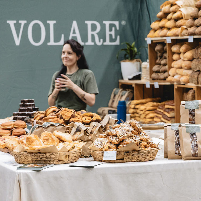 Elise standing behind a display of Volare baked goods at the Auckland Food Expo