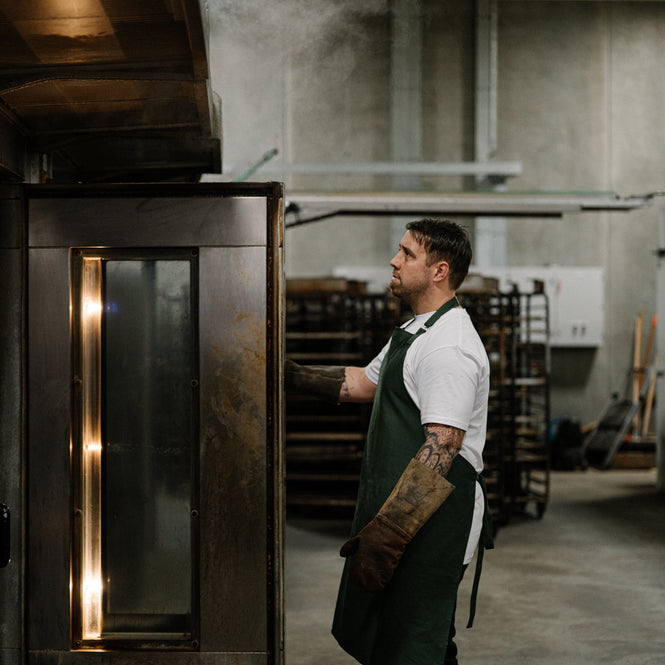Volare baker Ryan Simmons stands in front of oven with door open