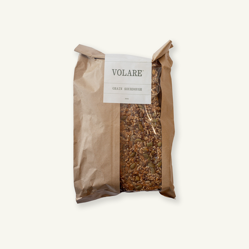 Sliced Volare Grain Sourdough in a brown paper bag with a window.