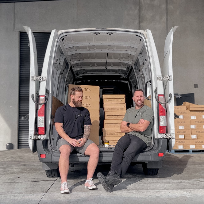 Founders of Volare Bread, Ed & Ryan, sitting in the back of a delivery van.